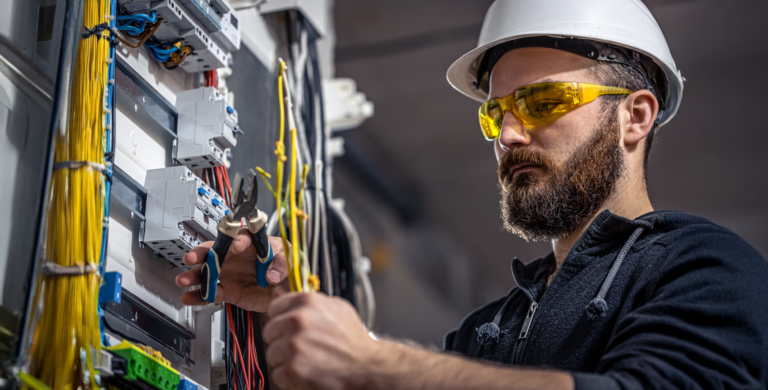 male-electrician-works-switchboard-with-electrical-connecting-cable